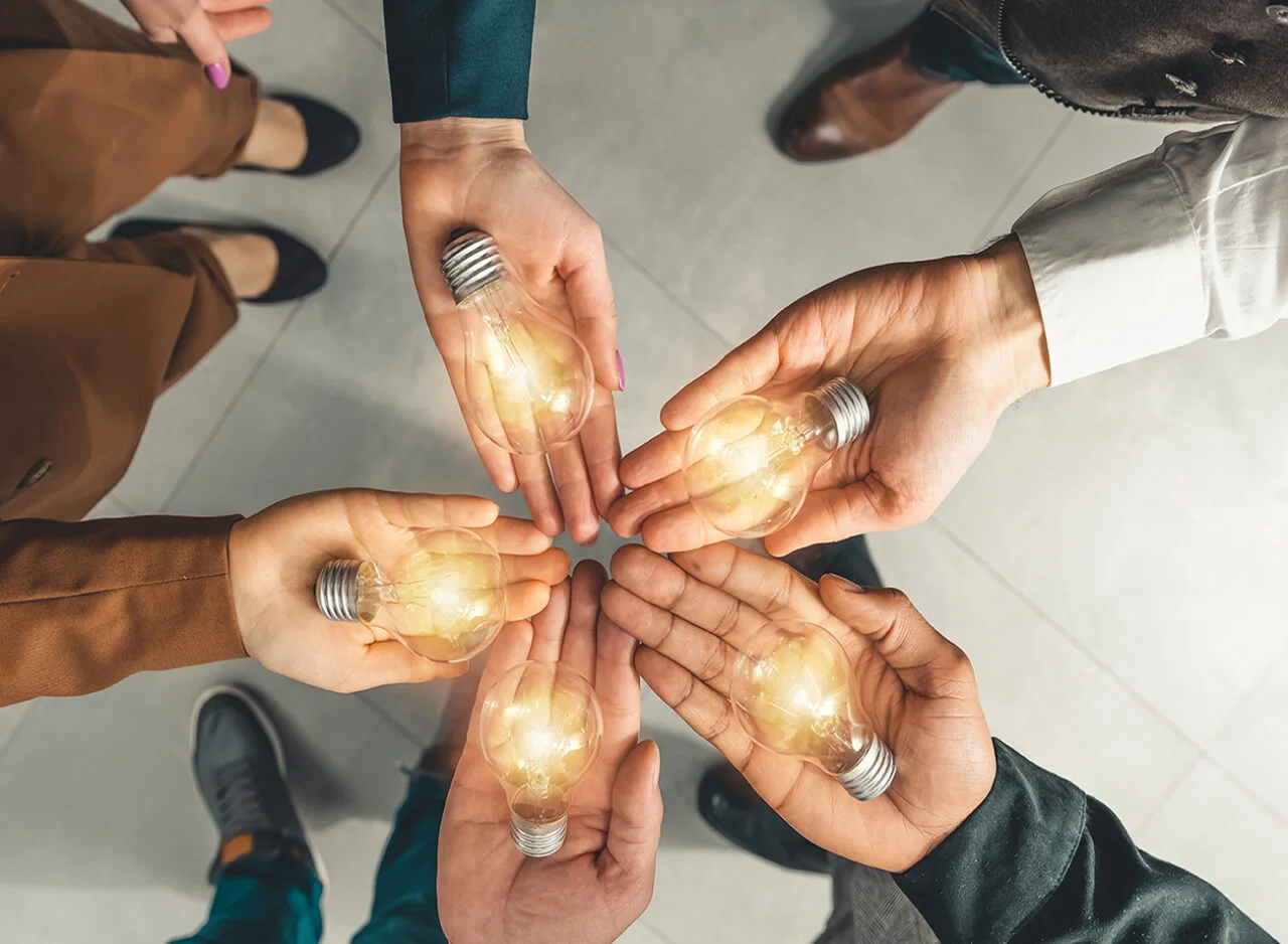 Solar & Energy Consulting GmbH - Team mit Ideenbirnen in den Händen 